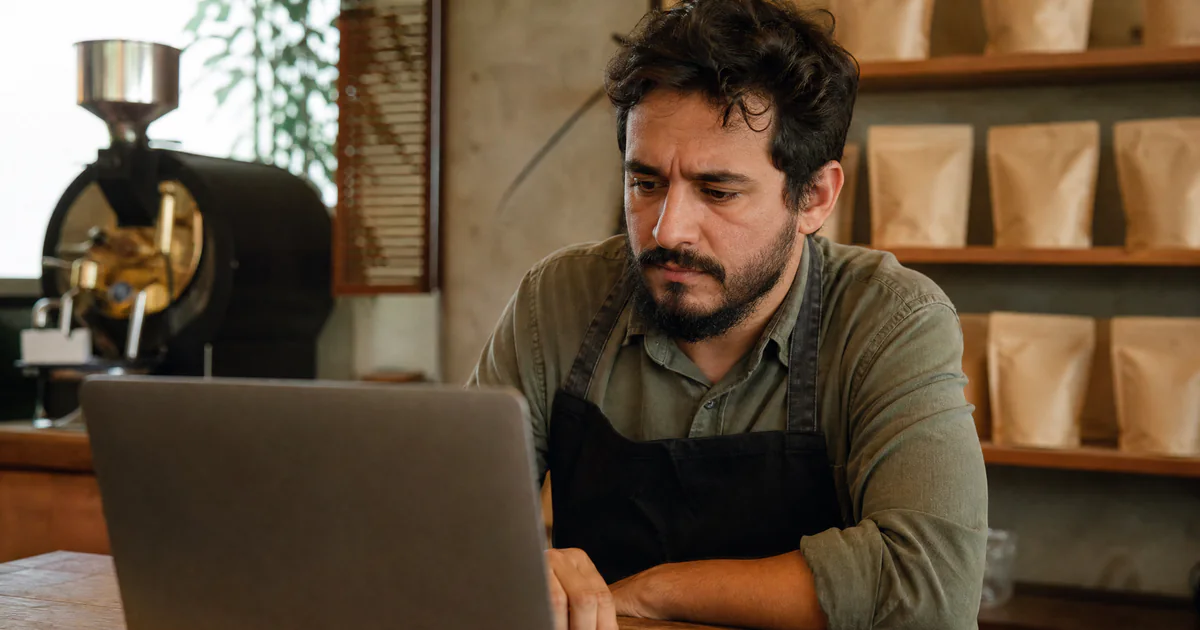 Empreendedor preocupado revisando o custo dos anúncios no notebook da loja