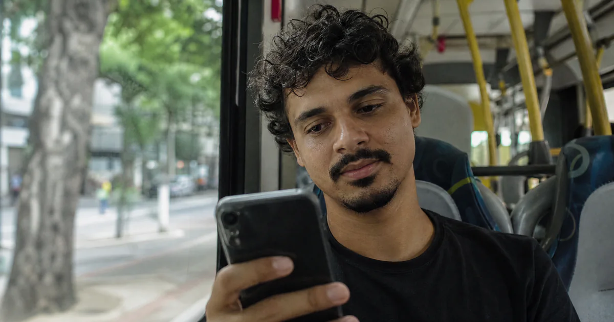 Pessoa rolando o feed do celular e parando num anúncio interessante