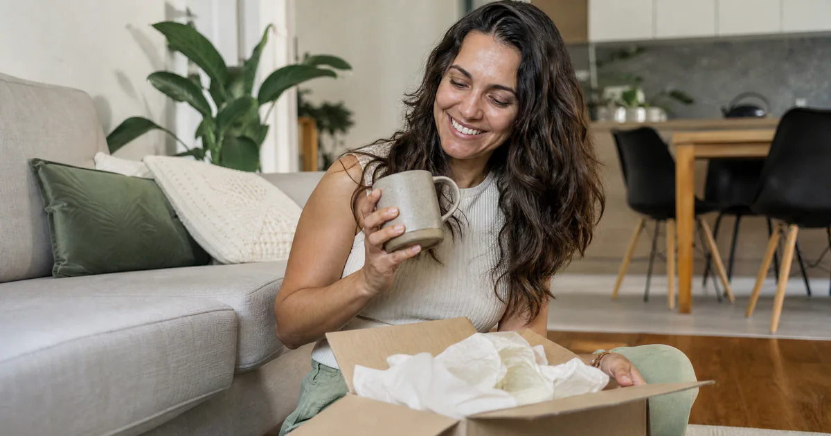 Cliente feliz abrindo o pacote que acabou de chegar em casa