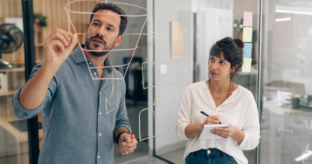 Estrategista de marketing desenhando o funil de vendas no quadro branco