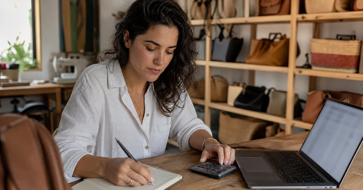 Empreendedora calculando os custos para abrir a loja virtual no ateliê