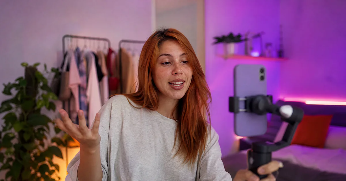 Jovem gravando vídeo vertical para anúncio no TikTok em estúdio caseiro
